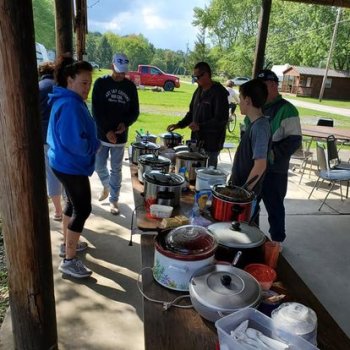 People standing by a table with soup