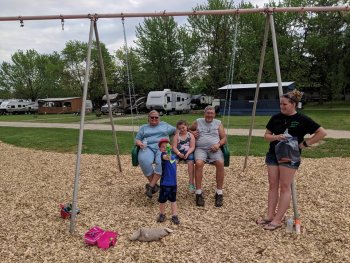 Family of camper's on a swing set at The Ridge Campground