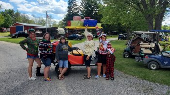 Ladies in ughly sweaters around golf cart