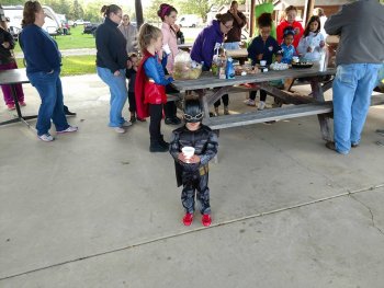 A young camper dressed at Batman enjoying some cider at The Ridge Campground